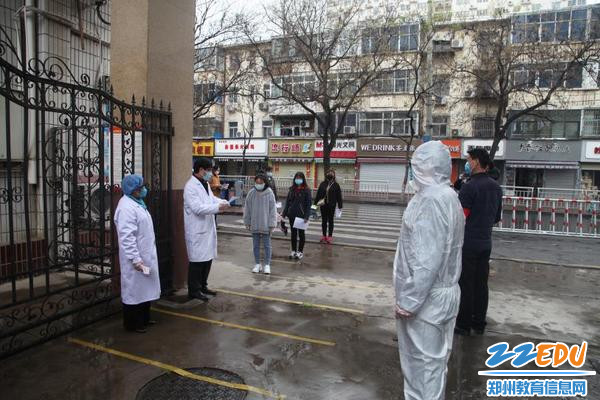 防控人员在演练中对出入人员进行登记、消毒、测量体温